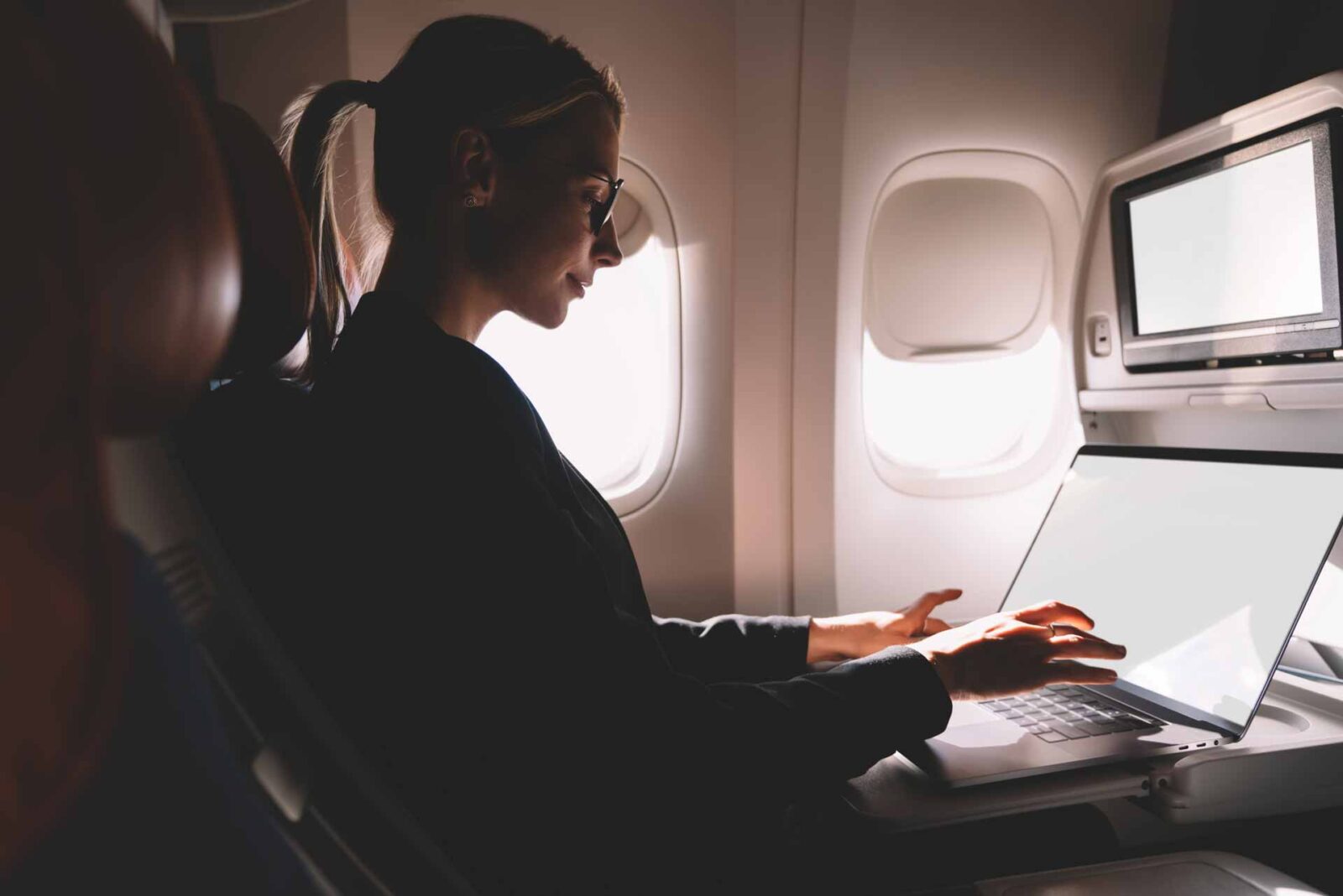 Contrast picture of blonde business woman working on a plane