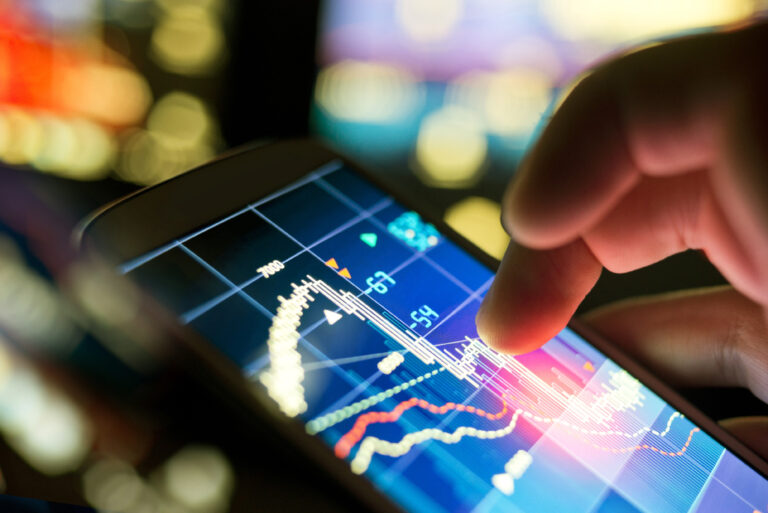 Close up focus of stock market data on a mobile phone with blurred background