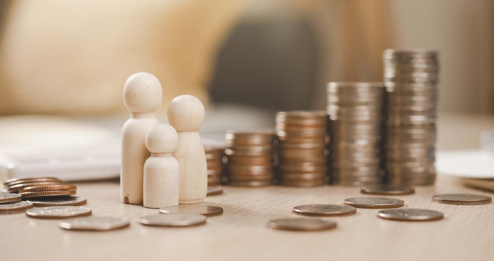 Wooden figurine of a family with a pile of coins around it